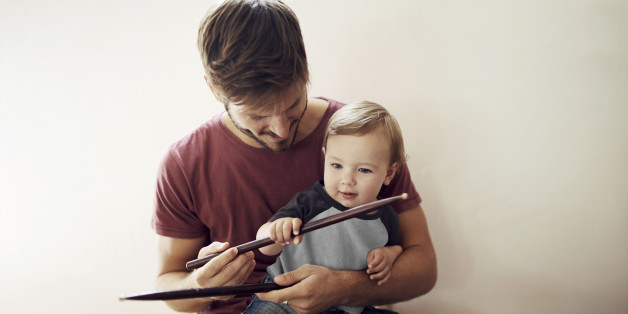 A handsome young father teaching his young son to drum