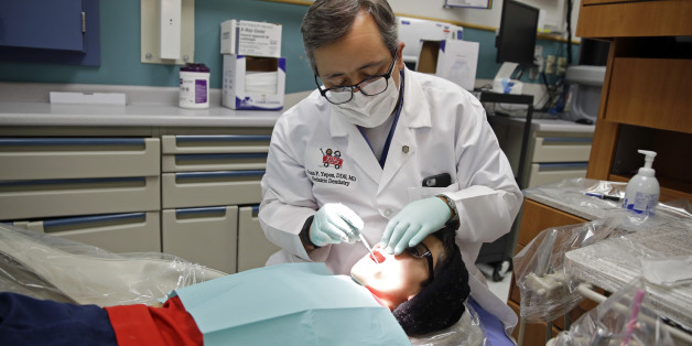 In this Friday, Jan. 22, 2016 photo, Dr. Juan Fernando Yepes, a dentist at the Riley Hospital for Children Department of Pediatric Dentistry, checks the teeth of Justin Perez, 11, during an office visit in Indianapolis. Medicaid covers dental care for an estimated 37 million children from low-income families. The state and federal Medicaid program varies by state, but there are national shortages of dentists who participate. (AP Photo/Michael Conroy)