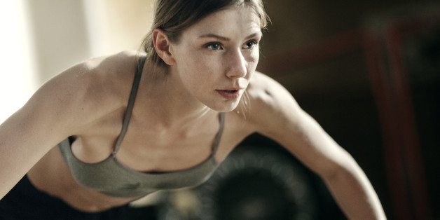 Close-up of focused female boxer doing push-ups in the gym