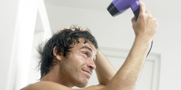 Man blow drying hair