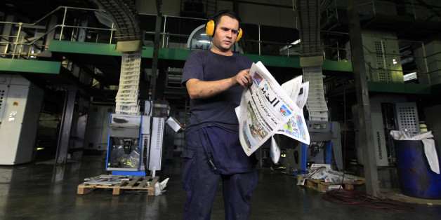 A pressman checks newly printed Al Khabar newspapers for printing errors at the printing presses owned by Algeria's Al Khabar and El Watan newspapers in Algiers September 20, 2010. REUTERS/Zohra Bensemra (ALGERIA - Tags: MEDIA)