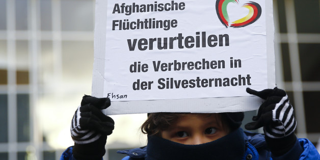 Ein afganisches Flüchtlingskind hält nach der Kölner Silvesternacht ein Plakat hoch, dass die Übergriffe verurteilt