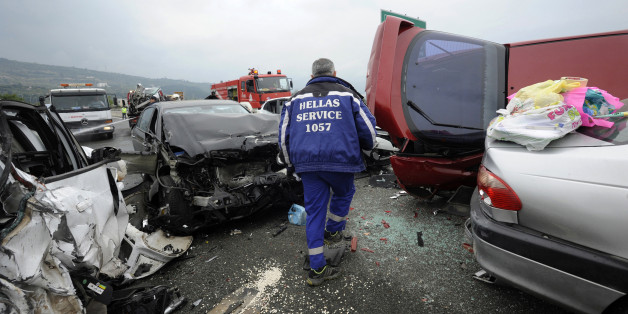A worker from a road assistance company walks through destroyed cars following a massive car accident on a motorway in northern Greece October 5, 2014. Greek media reported that a truck caused a pile-up with dozens of cars in which four people were killed and at least 20 were injured on Egnatia motorway a few kilometres off Thessaloniki. REUTERS/Alexandros Avramidis (GREECE - Tags: SOCIETY DISASTER TRANSPORT TPX IMAGES OF THE DAY)