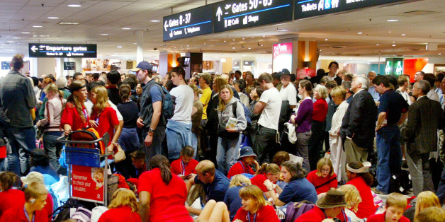 Hundreds of people wait outside the customs check point at Sydney international airport, Wednesday, July 7, 2004, after all fights were delayed due to a security breech. Delays of more than an hour were caused by a man being stopped while trying to get onto a flight without a boarding pass. (AP Photo/Rob Griffith)