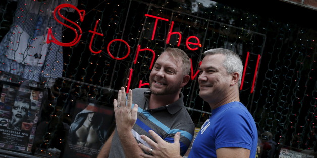 Charles Wooton (R) and Keith Newport, both from Atlanta, Georgia, show their wedding rings outside the Stonewall Inn in the Greenwich Village neighborhood of New York, June 26, 2015, following the announcement that the U.S. Supreme Court had ruled that the U.S. Constitution provides same-sex couples the right to marry in a historic triumph for the American gay rights movement. REUTERS/Mike Segar