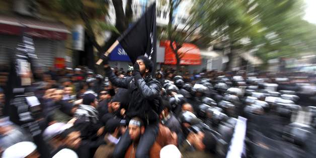 FILE - Tunisian Salafists confront police officers during a demonstration in Tunis, in this Friday, Feb. 17, 2012 file photo. The cradle of the Arab Spring, Tunisia also has a long history of frustrated youth heading off to fight in foreign jihads. Now, according to figures released by the Syrian government, they may make up a large percentage of Arabs who have gone to join the struggle against the regime of Bashar Assad. And that has raised alarm both about radicalization in the Syrian rebel movement, and of rising extremism within newly-democratic Tunisia itself. (AP Photo/Amine Landoulsi, File)