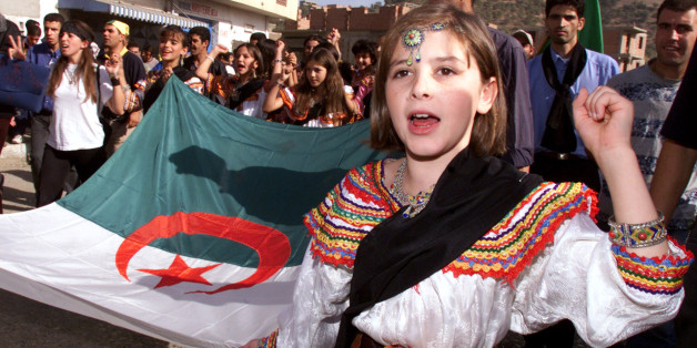 A young girl from the Kabylie region wears a traditional costume as sheholds the Algerian flag during a march in Ighil Imoula, some 100 kmseast of the country's capital of Algiers, November 1, 2001. Severalthousand people from the restive Berber-speaking Kabylie region,traditionally a region of opposition to central rule, march to maintainpressure on the Algerian government about deep-rooted grievances.REUTERS/Zohra BensemraZB/JES/