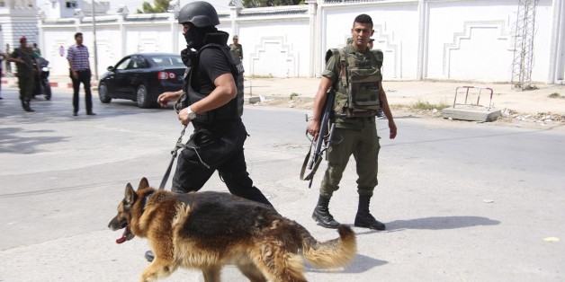 A Tunisian anti-terrorism brigade officer leads his dog after a shooting at the Bouchoucha military base in Tunis, Tunisia May 25, 2015. A Tunisian soldier opened fire on colleagues at a military base in the capital Tunis on Monday, killing a colonel and wounding eight other soldiers before he was shot dead himself, an army spokesman and a security source said. REUTERS/Zoubeir Souissi