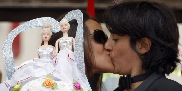 A lesbian couple kisses near a wedding cake as they take part in a gay pride parade in Rome June 7, 2008. Some 10,000 dancing and singing homosexuals and gay-rights supporters marched through Rome on Saturday, many of them chanting slogans against the Vatican and Italy's conservative new government. REUTERS/Alessandro Bianchi (ITALY)