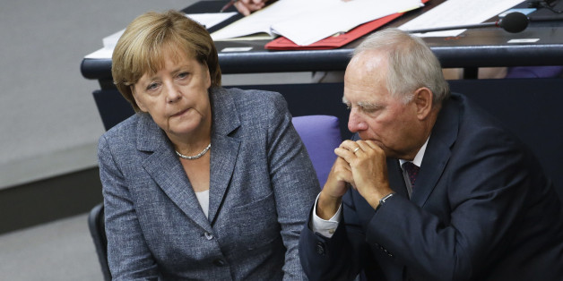 German Chancellor Angela Merkel, left, talks to Finance Minister Wolfgang Schaeuble during a debate at the German parliament prior to a vote on another bailout package for Greece, in the German Bundestag in Berlin, Wednesday, Aug. 19, 2015. (AP Photo/Markus Schreiber).