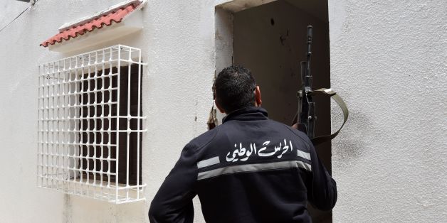 A Tunisian gendarme stands guard outside a house where two suspected jihadists were killed during a security operation on May 11, 2016 in the town of Mnihla, in Ariana province just outside Tunis. Sixteen others, some of them armed, were arrested during the operation, the interior ministry said in a statement. Since its 2011 revolution, Tunisia has faced a growing jihadist threat, with the Islamic State group last year claiming a string of deadly attacks on holidaymakers and security forces that