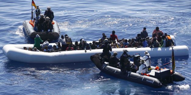 German Navy sailors surround a boat with more than 100 migrants near the German combat supply ship 'Frankfurt am Main' while operating in EUNAVFOR Med, also known as Operation Sophia, in the Mediterranean Sea off the coast of Libya Tuesday, March 29, 2016. (AP Photo/Matthias Schrader)