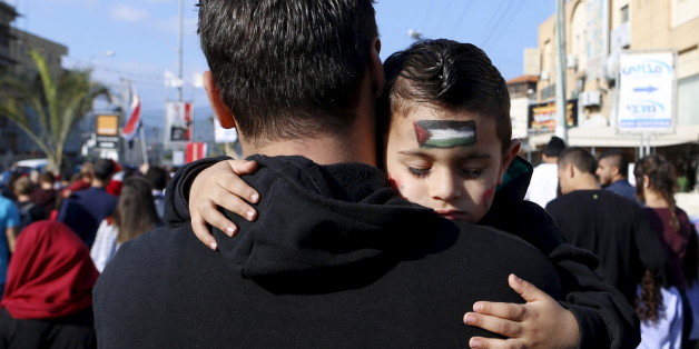An Israeli Arab boy sleeps as his father carries him during a Land Day rally in the northern Israeli village of Arrabe, March 30, 2016. Land Day commemorates the killing of six Arab citizens of Israel by security forces during protests in 1976 over government land confiscations. REUTERS/Ammar Awad TPX IMAGES OF THE DAY