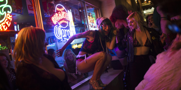 An exotic dancer performs outside a bar window on Columbus Avenue during a funeral procession to symbolize the closure of Lusty Lady strip club in San Francisco, California September 1, 2013. United States' first and only unionized, employee-owned strip club shuts its doors on September 2 after its landlord refused to negotiate on a lower rent, local media reported Picture taken September 1, 2013. REUTERS/Stephen Lam (UNITED STATES - Tags: BUSINESS SOCIETY)