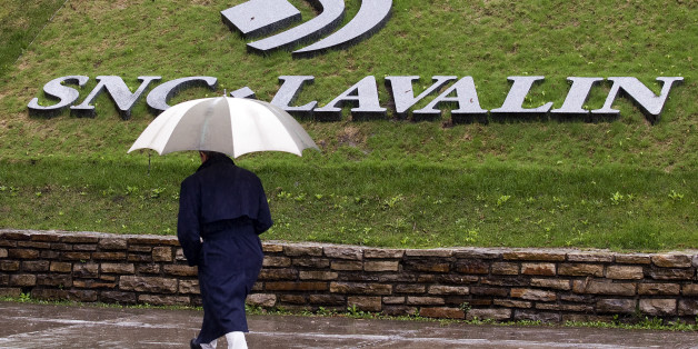 A pedestrian walks past the SNC-Lavalin Group Inc., headquarters in Montreal, May 7, 2009. SNC-Lavalin Group Inc reported a nearly 10 percent increase in first-quarter profit on Thursday, as the big Canadian engineering and construction company recorded larger gains from infrastructure concession investments such as toll roads. REUTERS/Christinne Muschi (CANADA BUSINESS)