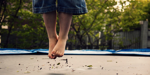 Boy bouncing on trampoline.