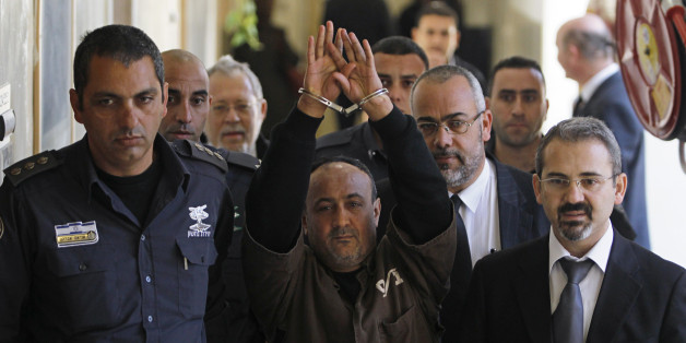 An Israeli prison guard escorts jailed Fatah leader Marwan Barghouti (C) to a deliberation at Jerusalem Magistrate's court January 25, 2012. Convicted of murder for his role in attacks on Israelis, Barghouti was jailed for life by Israel in 2004.
REUTERS/Baz Ratner (JERUSALEM - Tags: POLITICS CRIME LAW)