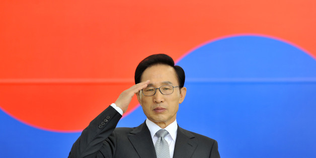South Korean President Lee Myung-bak salutes in front of the national flag during a ceremony to mark the 64th Armed Forces Day, which will fall on Oct. 1, at the Gyeryong military headquarters in Gyeryong, South Korea, Wednesday, Sept. 26, 2012. (AP Photo/Jung Yeon-je, Pool)