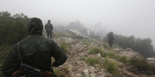 Algerian soldiers walk near the wreckage of a military plane which crashed near the village of Ouled Gacem in eastern Algeria, about 500km (311 miles) from the capital Algiers February 12, 2014. The military transport plane carrying members of the Algerian armed forces and their relatives crashed into a mountain on Tuesday, killing 77 people, the worst air disaster in the North African country in a decade. REUTERS/Louafi Larbi (ALGERIA - Tags: TRANSPORT DISASTER MILITARY)