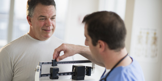 USA, New Jersey, Jersey City, Doctor assisting male patient on weighing scales in hospital