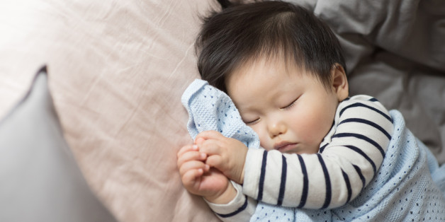 11 months old baby boy sleeping on bed