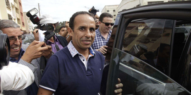 Ali Anouzla (C), the editor of current affairs website Lakome.com, smiles after being released on bail in Rabat October 25, 2013. The Moroccan news editor facing terrorism charges for posting a link to an al Qaida video on his website was released on bail on Friday, his defence lawyer said. Police arrested Anouzla on September 17 after he added a link to a page on Spanish news site El Pais. The page contained the al Qaeda video in which militants threatened Morocco's King Mohammed and urged youn