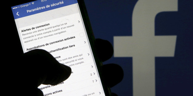 A man reads parameters of security on his phone in front of a displayed Facebook logo in Bordeaux, southwestern France, March 10, 2016. REUTERS/Regis Duvignau/Illustration