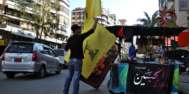 In this Feb. 29, 2016 photo, a vendor sells Hezbollah and religious flags and other memorabilia , in the southern suburbs of Beirut, Lebanon. Lebanon's central bank governor said Monday, April 18, 2016 that Beirut will abide by a U.S. law that imposes sanctions on banks that knowingly do business with the militant Hezbollah group. (AP Photo/Bilal Hussein)