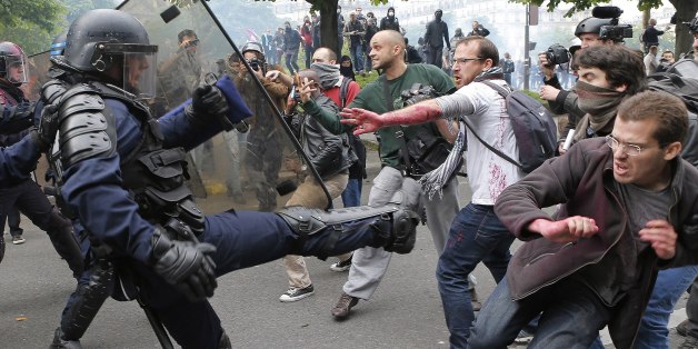 Riot police officers clash with protestors during a demonstration held as part of nationwide labor actions in Paris, France, Thursday, May 26, 2016. French protesters scuffled with police, dock workers set off smoke bombs and union activists disrupted fuel supplies and nuclear plants Thursday in the biggest challenge yet to President Francois Hollande's government as it tries to give employers more flexibility (AP Photo/Francois Mori)