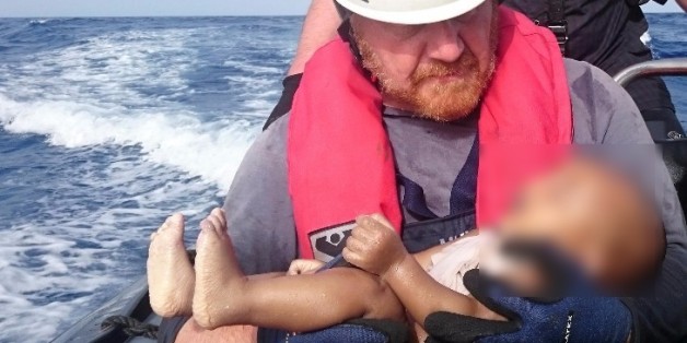 Ein Sea-Watch-Helfer hält eine Babyleiche im Arm.