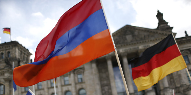 Supporters wave Armenian and German flags in front of the Reichstag, the seat of the lower house of parliament Bundestag in Berlin, Germany, June 2, 2016, as they protest in favour of approval of a symbolic resolution by Germany's parliament that declares the 1915 massacre of Armenians by Ottoman forces a "genocide". REUTERS/Hannibal Hanschke