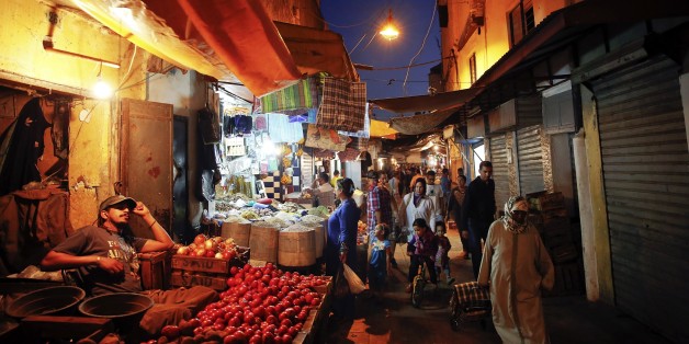 People shop for food in a narrow street of Rabat's Medina September 25, 2014. UNESCO made Rabat a World Heritage Site two years ago and media and tour operators call it a "must-see destination." But it seems the tourist hordes have yet to find out. While visitors are getting squeezed through the better-known sites of Marrakesh and Fez, the old part of Rabat - with its beautiful Medina and Kasbah of the Udayas - remains an almost unspoiled oasis of calm. Smaller and more compact, its labyrinths o