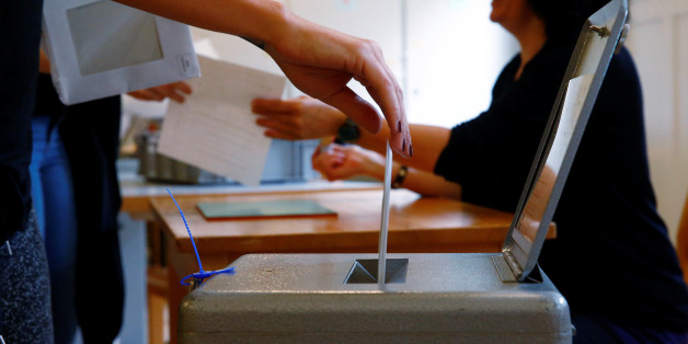 People cast their ballots during a vote on whether to give every adult citizen a basic guaranteed monthly income of 2,500 Swiss francs ($2,560), in a school in Bern, Switzerland, June 5, 2016. REUTERS/Ruben Sprich