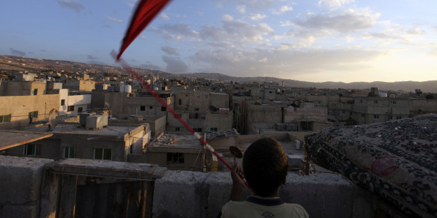 Mohamad Saada, 16, waves a red flag to call his pigeons at al-Baqaa camp, the largest of ten official Palestinian refugee camps north of Amman, Jordan, consisting of over 100,000 residents, Friday, Sept. 23, 2011. (AP Photo/Mohammad Hannon)