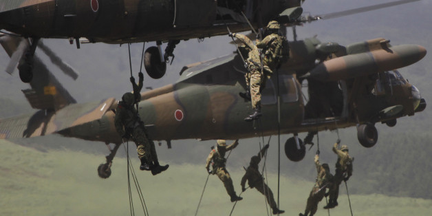 FILE - In this Tuesday, Aug. 21, 2012 file photo, members of Japan Ground Self-Defense Force rappell down from a UH-60JA helicopter during the annual live-fire drill at the Higashi Fuji training range in Gotemba, southwest of Tokyo. The new defense plan, approved on Tuesday Dec. 17, 2013, calls for setting up an amphibious unit similar to the U.S. Marines as part of the ground defense forces to respond quickly in case of a foreign invasion of those islands. (AP Photo/Koji Sasahara, File)