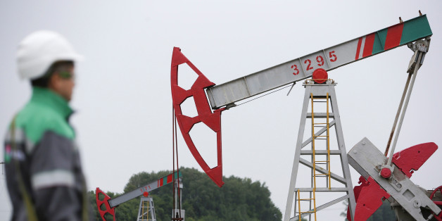 A worker looks at a pump jack at an oil field Buzovyazovskoye owned by Bashneft company north from Ufa, Bashkortostan, Russia, July 11, 2015. REUTERS/Sergei Karpukhin/File Photo