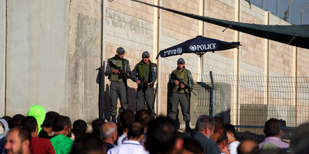 Israeli border police officers stand guard as Palestinians wait to cross through the Qalandia checkpoint to make their way to attend the first Friday prayer of the holy fasting month of Ramadan in Jerusalem's al-Aqsa mosque, near the West Bank city of Ramallah June 10, 2016. REUTERS/Mohamad Torokman