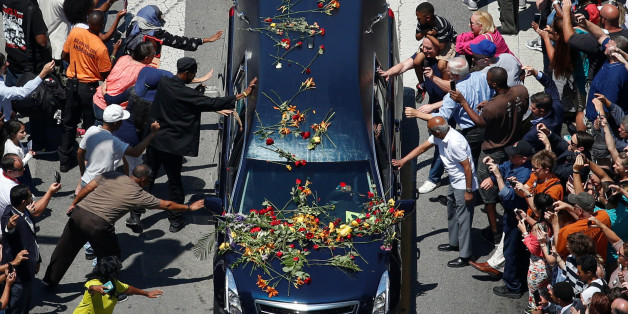 Well-wishers touch the hearse carrying the body of the late boxing champion Muhammad Ali during his funeral procession through Louisville, Kentucky, U.S., June 10, 2016. REUTERS/Adrees Latif TPX IMAGES OF THE DAY
