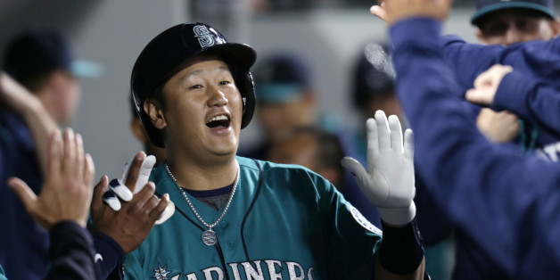 Seattle Mariners' Dae-Ho Lee is congratulated in the dugout after hitting a solo home run on a pitch from Texas Rangers' Derek Holland during second inning of a baseball game on Friday, June 10, 2016, in Seattle. (AP Photo/John Froschauer)