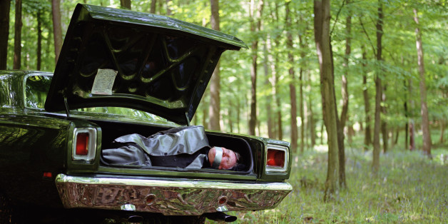 Car in woodland, mature man gagged and bound in boot