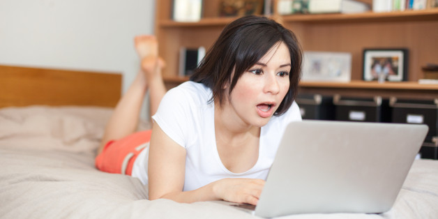Überraschte Frau vor Laptop