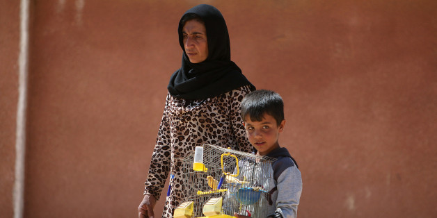 A woman and a boy that fled Manbij city carry a bird cage after arriving in the areas that Syria Democratic Forces (SDF) alliance forces took control of on the outskirts of Manbij city, Aleppo province, Syria June 8, 2016. REUTERS/Rodi Said