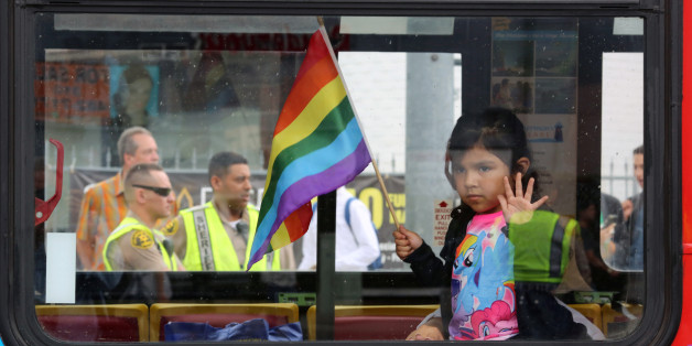 Los Angeles County Sheriff's deputies are seen behind a girl riding in a bus at the 46th annual Los Angeles Gay Pride Parade in West Hollywood, California, after a gunman opened fire at a gay nightclub in Orlando, Florida U.S. June 12, 2016. REUTERS/David McNew