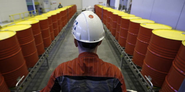 An employee stands in front of lines of oil barrels at Royal Dutch Shell Plc's lubricants blending plant in the town of Torzhok, north-west of Tver, November 7, 2014. Picture taken November 7, 2014. REUTERS/Sergei Karpukhin (RUSSIA - Tags: BUSINESS INDUSTRIAL)