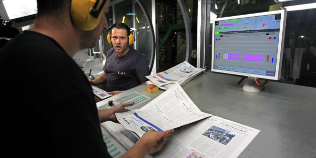 Pressmen check newly printed Al Khabar newspapers for printing errors at the printing presses owned by Algeria's Al Khabar and El Watan newspapers in Algiers September 20, 2010. Media in most of the Arab world are muzzled by official censorship, outright intimidation or subtle pressure but Algeria's leading newspapers stand out for the role they have taken on as feisty and outspoken champions of free speech. REUTERS/Zohra Bensemra (ALGERIA - Tags: MEDIA BUSINESS POLITICS)