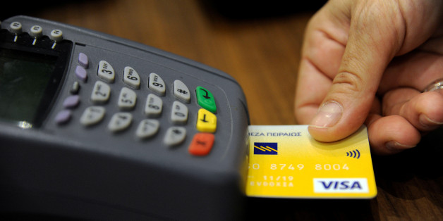 A sales staff accepts payment by credit card through a point-of-sale (POS) device at a boutique shop in central Athens, Greece, May 10, 2016. Picture taken May 10, 2016. REUTERS/Michalis Karagiannis