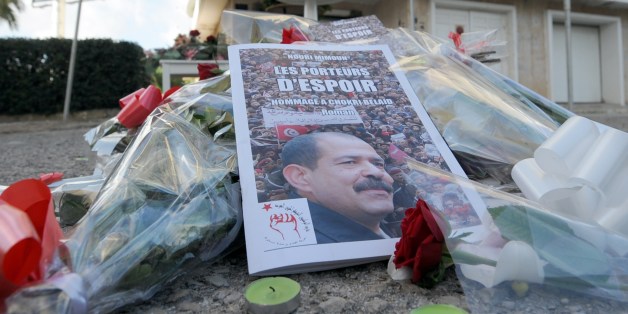 Flowers are laid at a memorial for slain opposition leader Chokri Belaid (portrait) set up at the site where he was murdered one year ago, on February 6, 2014 in Tunis. Tunisians today marked 12 turbulent months since the assassination of opposition politician Chokri Belaid, with his family still demanding to know what happened despite the alleged assassin being shot dead this week. AFP PHOTO / FETHI BELAID (Photo credit should read FETHI BELAID/AFP/Getty Images)