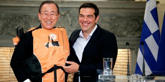 Le secrétaire général de l'ONU Ban Ki-moon (g) en gilet de sauvetage offert par le Premier ministre grec Alexis Tsipras (d) comme un "symbole" des traversées périlleuses des migrants, le 18 juin à Athènes