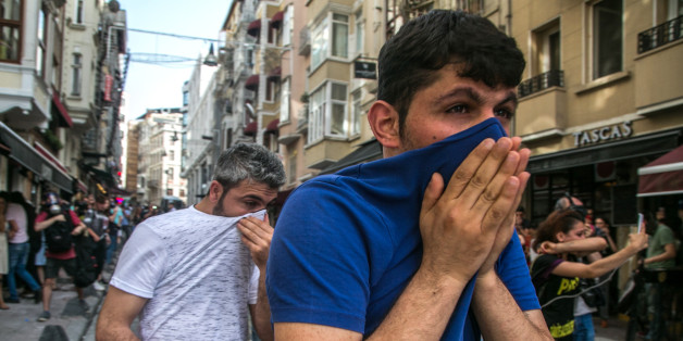 People cover their face with t-shirts as Turkish anti-riot police officers fire rubber bullets to disperse demonstrators gathered for a rally staged by the LGBT community on Istiklal avenue in Istanbul on June 19, 2016.
Turkish riot police fired rubber bullets and tear gas to break up a rally staged by the LGBT community in Istanbul on June 19 in defiance of a ban. Several hundred police surrounded the main Taksim Square -- where all demonstrations have been banned since 2013 -- to prevent the 'Trans Pride' event taking place during Ramadan. / AFP / GURCAN OZTURK (Photo credit should read GURCAN OZTURK/AFP/Getty Images)