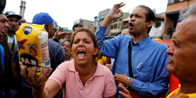A woman shows a flour package outside a supermarket as they shout slogans over food shortage in Caracas, Venezuela, June 11, 2016. REUTERS/Ivan Alvarado/File Photo